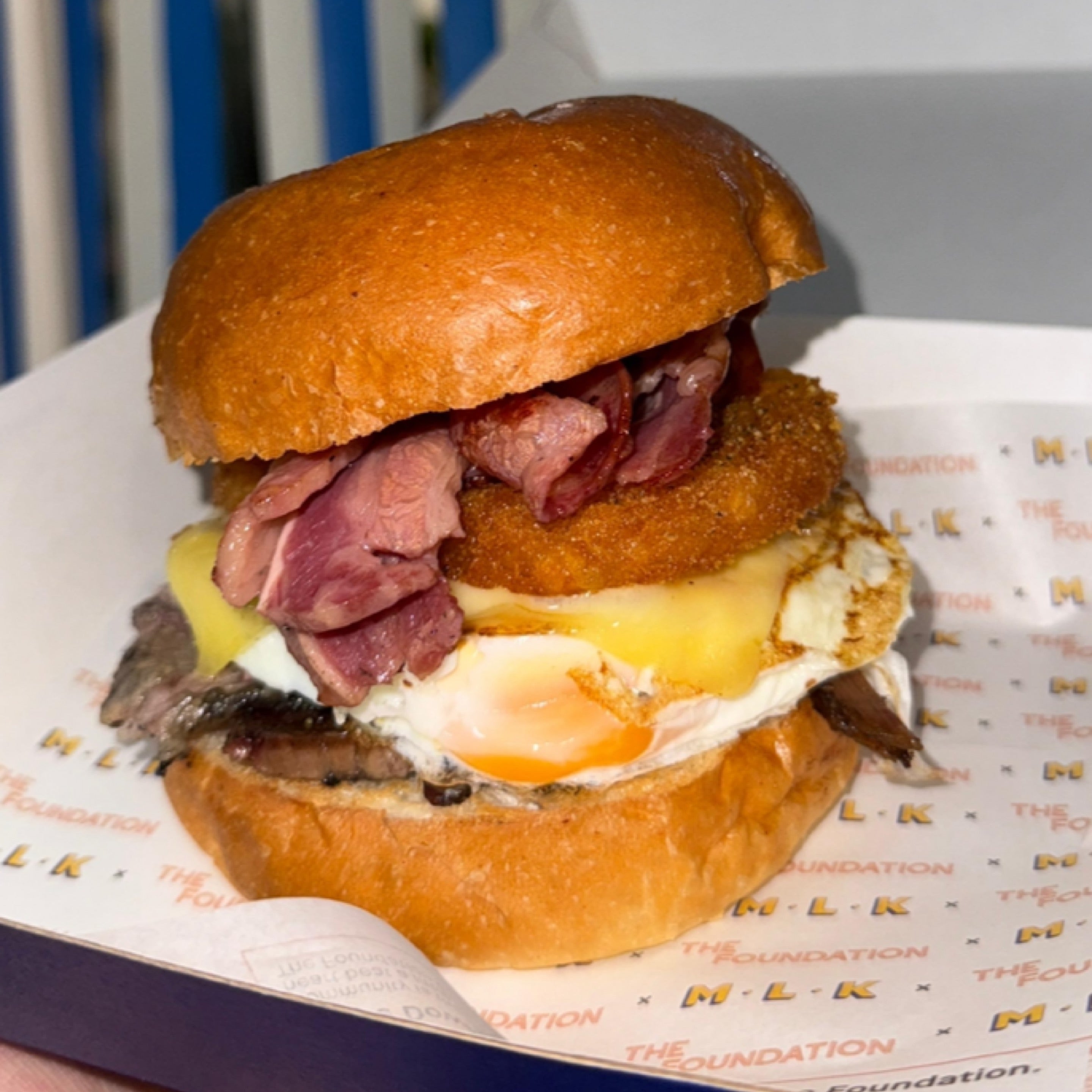 MLK Deli Brekky Brisket breakfast roll with eggs and hash brown